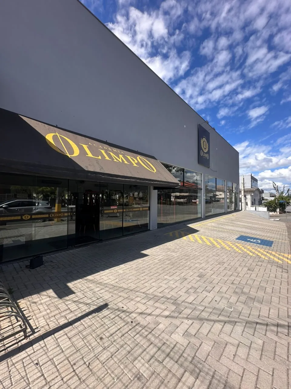 Fachada da Olimpo Atena, com o toldo amarelo Academia Olimpo
